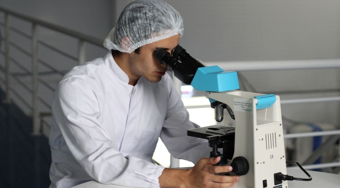 scientist using a microscope