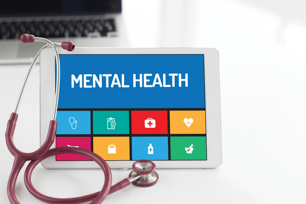 doctor's stethoscope in pink/red with a tablet saying mental health