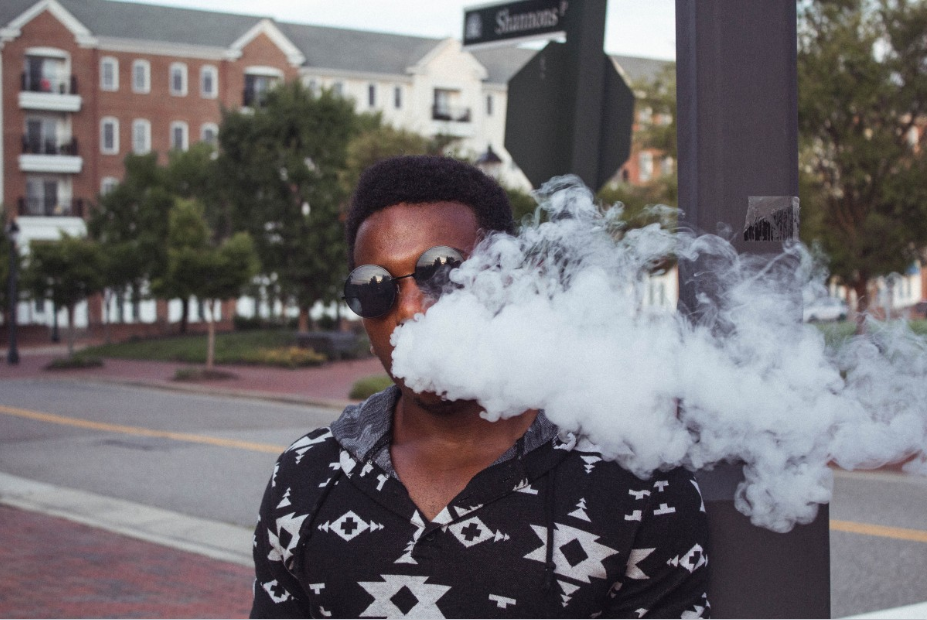 man in sunglasses vaping with a big cloud