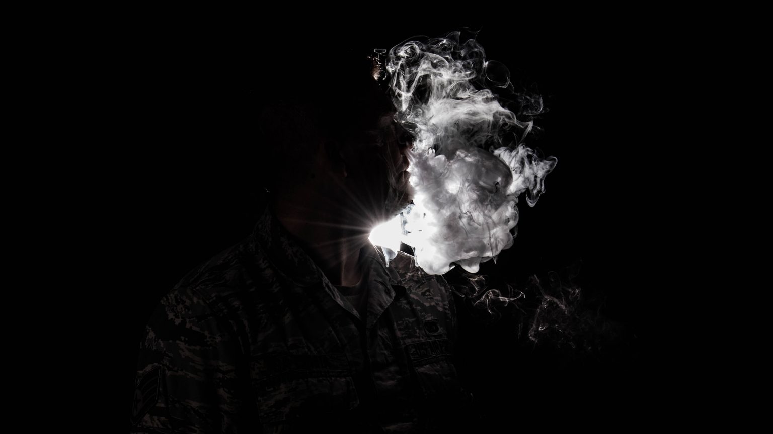 a vaper blowing big clouds in a black and white contrast