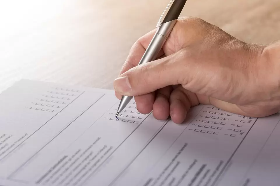 a person completing a survey with a silver pen