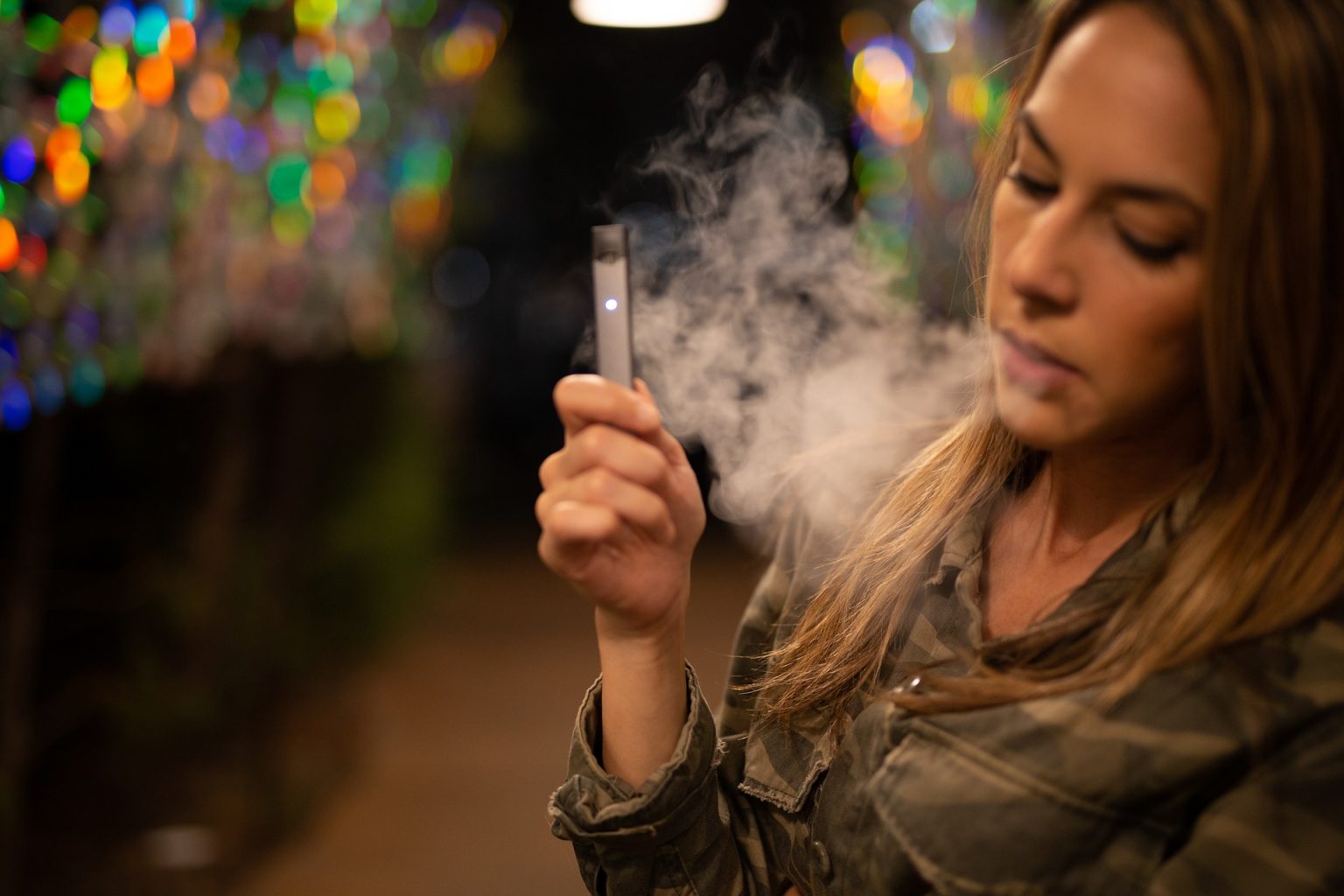 a young woman vaping on a JUUL vaping device