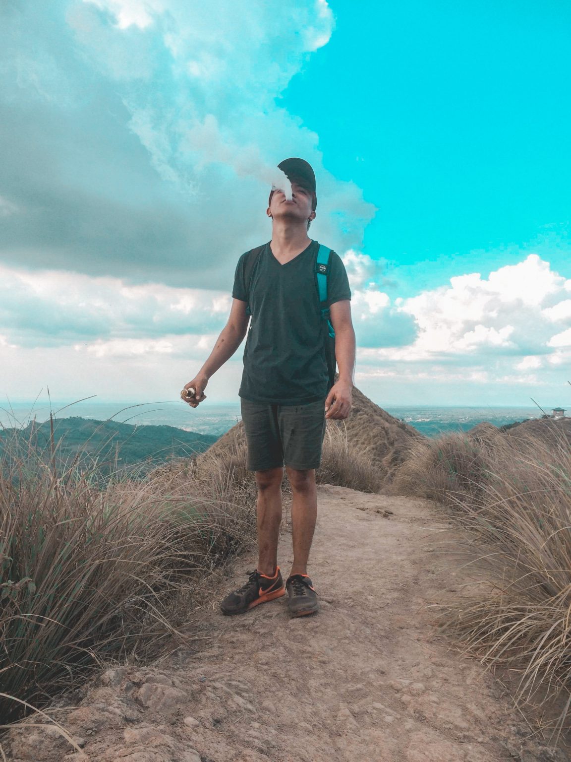 man walking up a mountain vaping