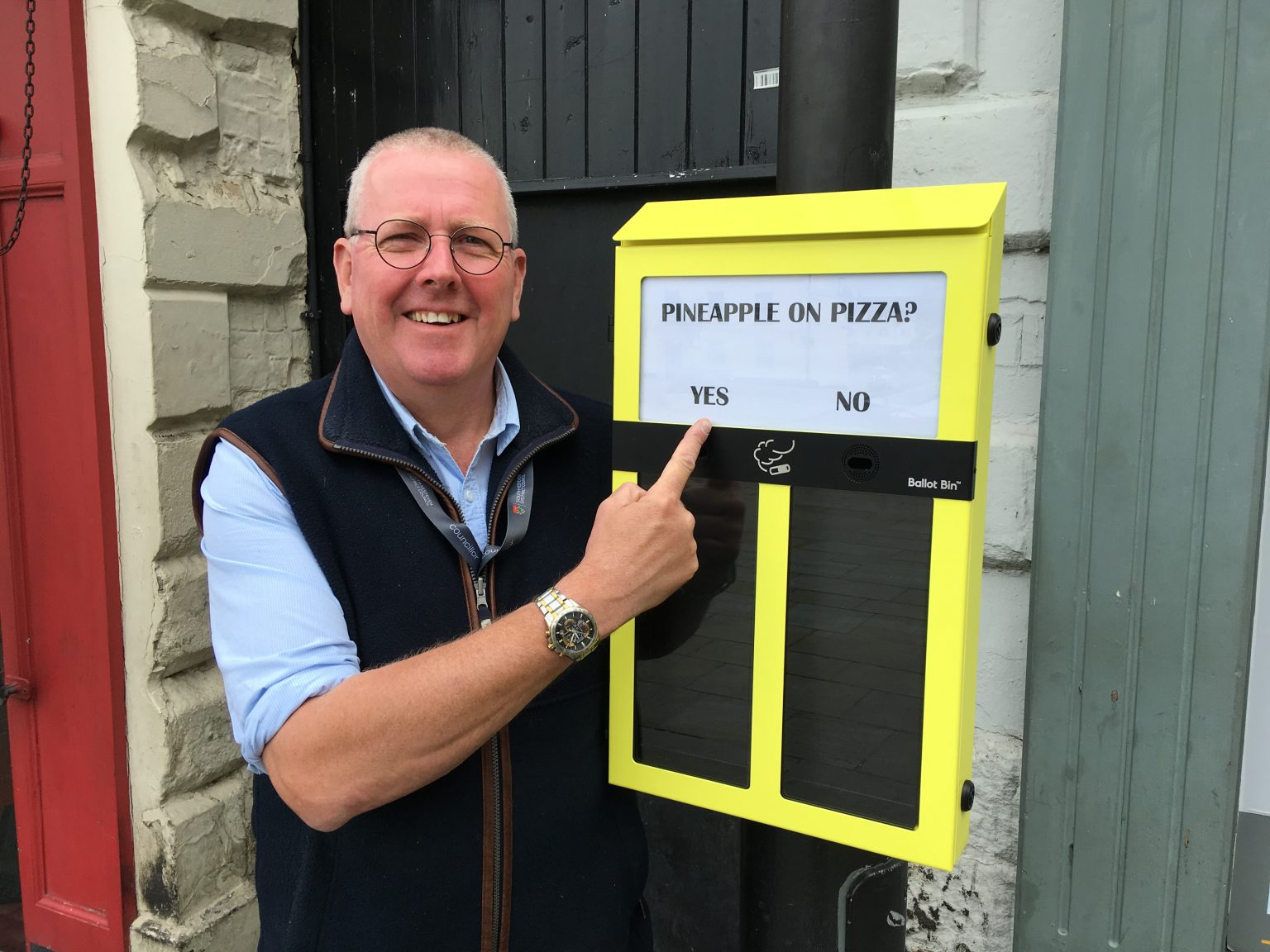 Dr Peter Moseley pointing to cigarette voting ballot box