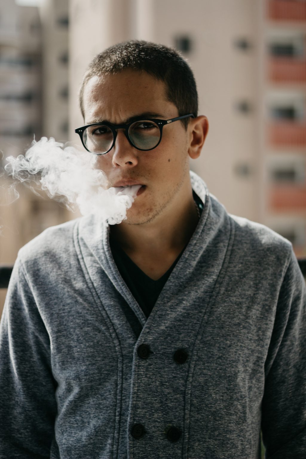 a man in a grey woolly jumper vaping