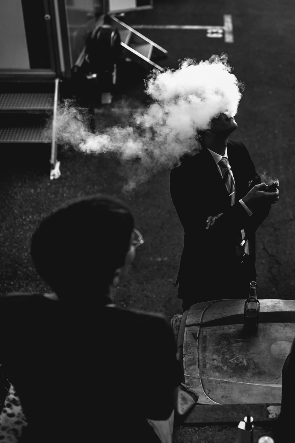 man in a suit and tie vaping