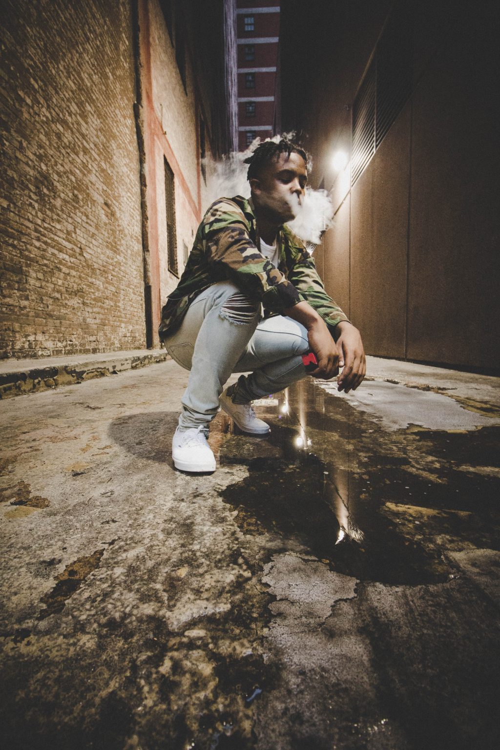 a man in an alley vaping