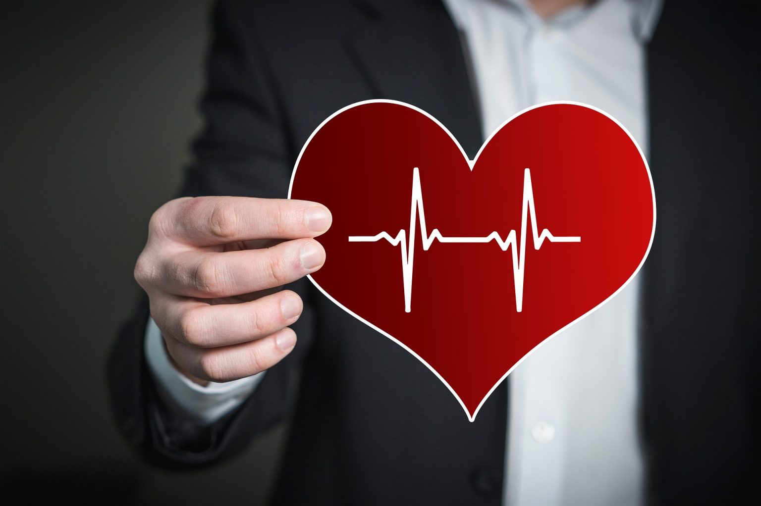 a man holding a graphic of a red heart