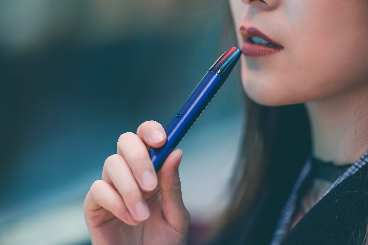 woman holding blue vape