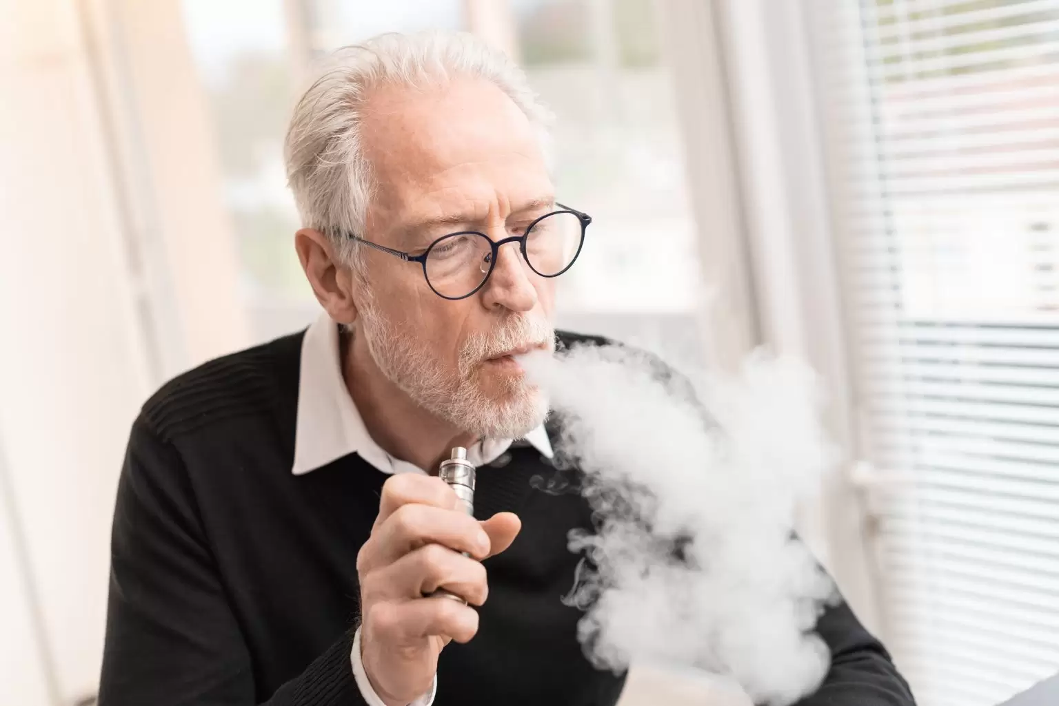 older man vaping and producing big clouds