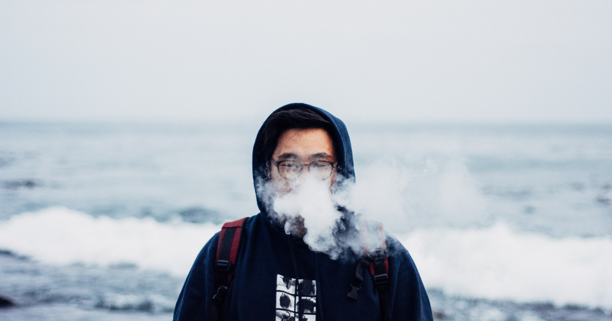 Man vaping by the sea