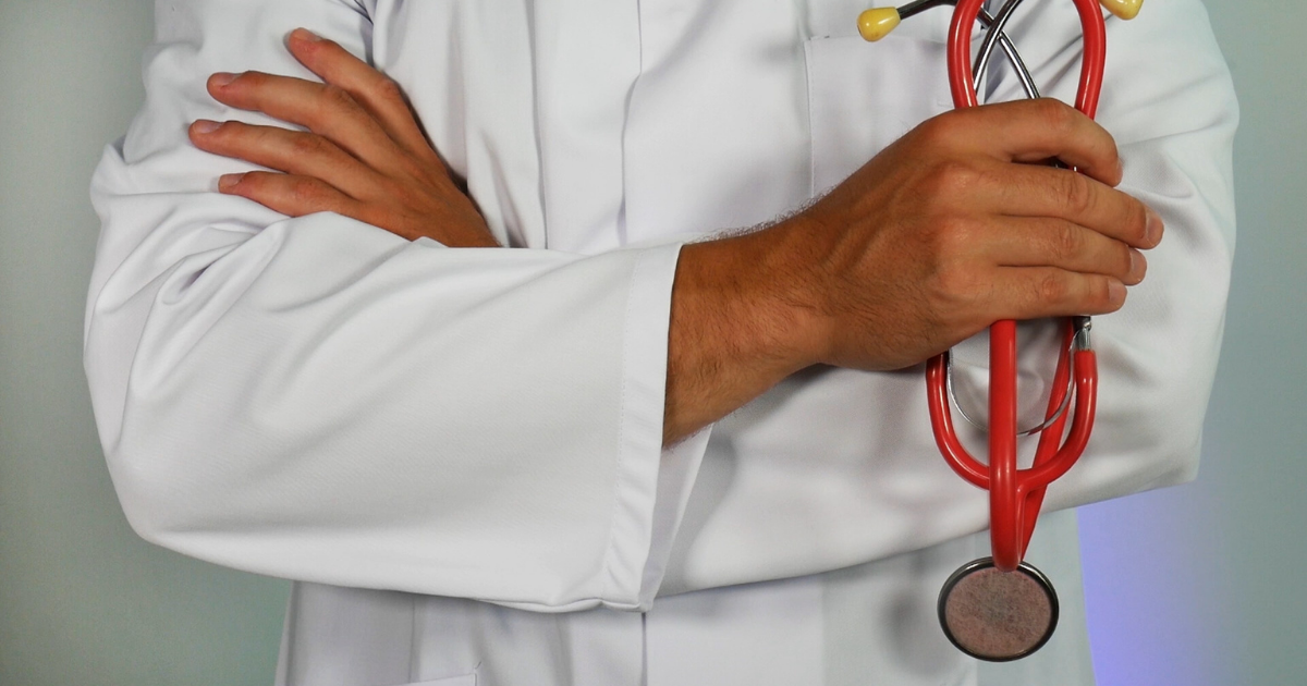 Doctor with folded arms holding a stethoscope