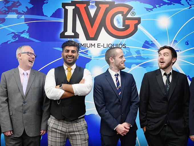 men in suits stood in front of IVG advertisement