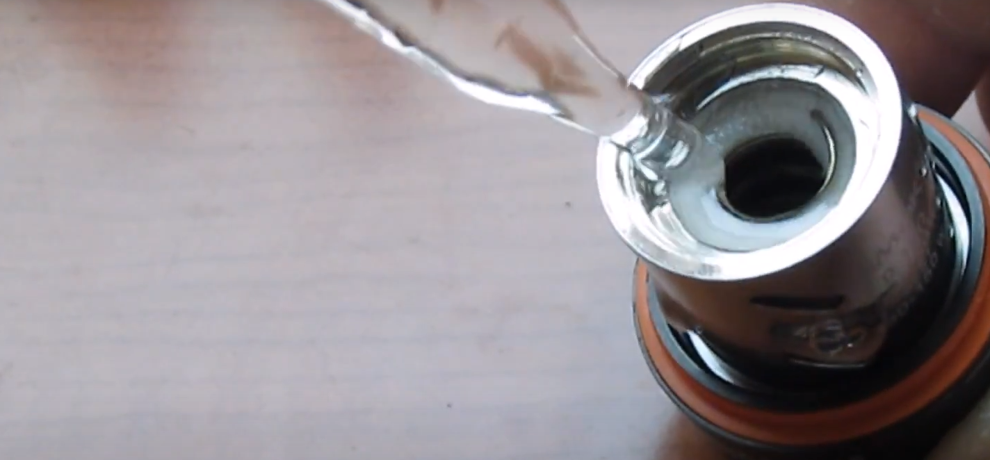 e-liquid being poured into a new vape coil -priming coils