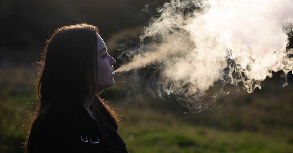 Woman vaping outdoors