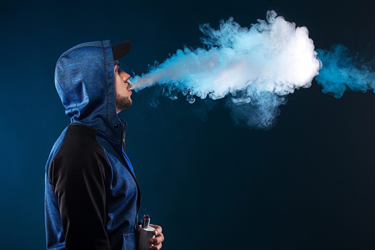 Man in hoody vaping