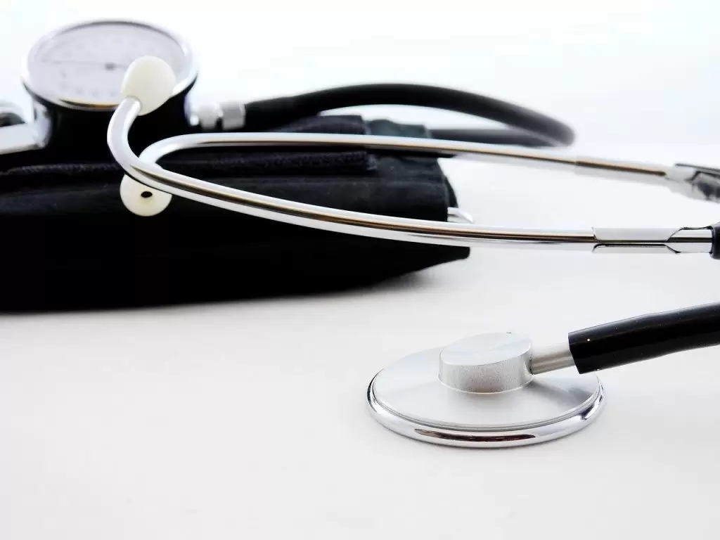 A silver and black doctors stethoscope lying on its side.