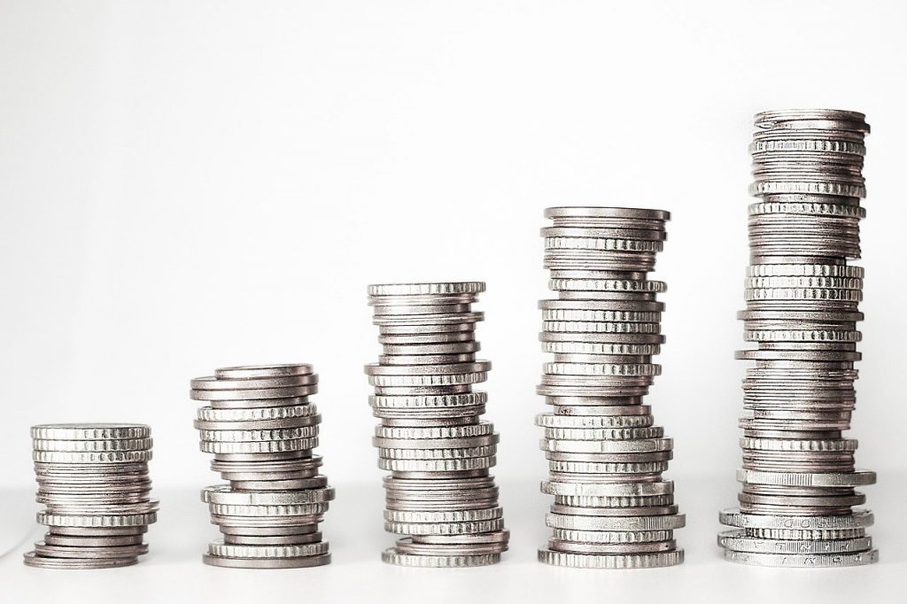 5 stacks of silver coins at various heights ranging from small to large on a white background.