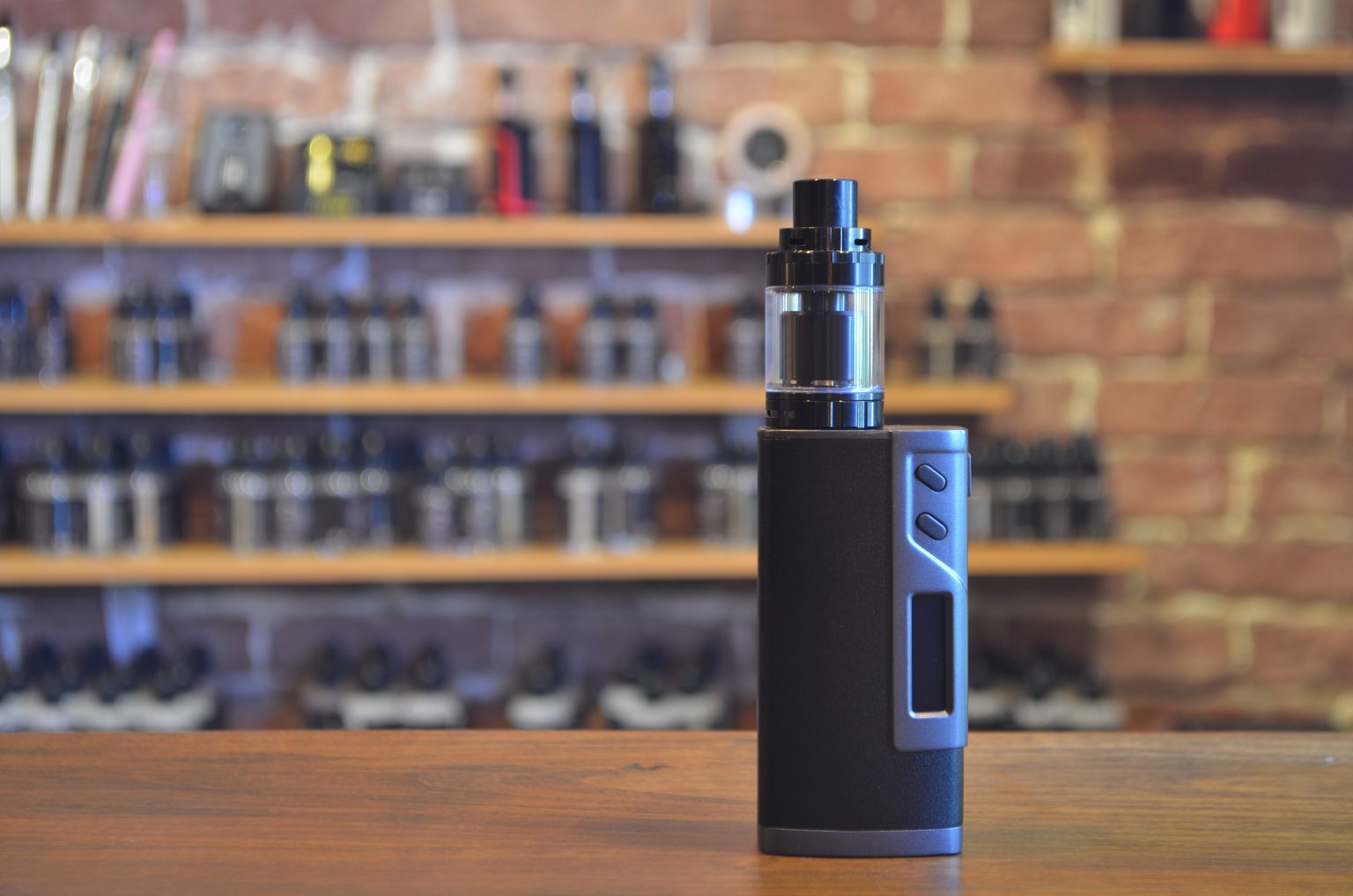 Electronic cigarette on a background of vape shop. E-cigarette for vaping. Popular vape devices at a vape shop