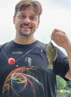 michael redfern holding a caught fish up in the air