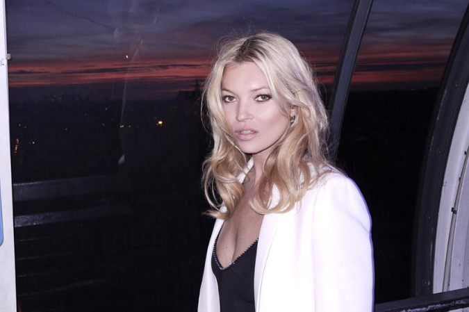 kate moss posing in front of a sunset