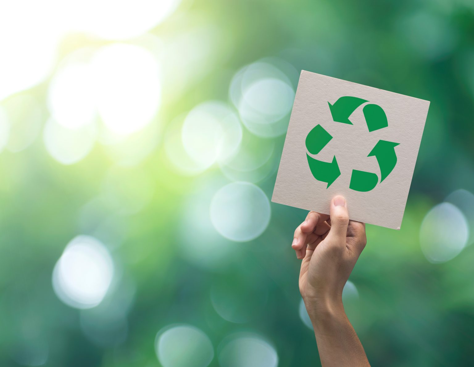 Hand holding recycle symbol on green bokeh background. eco and save the earth concept.