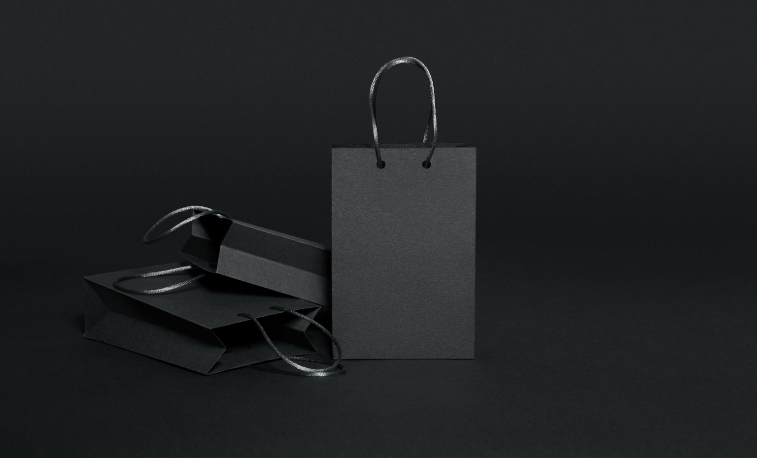 Black shopping bags on black background