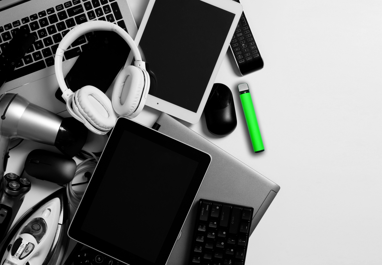 pile of electronical devices on grey surface, headphones, laptop, ipad, vape, tablet