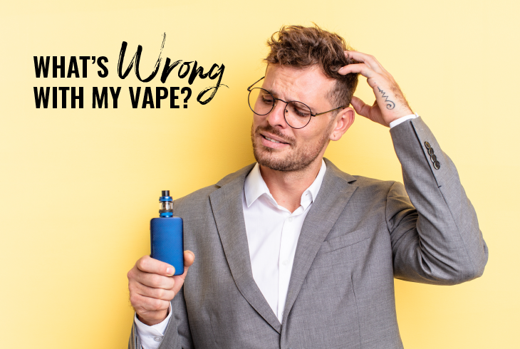 A young blonde man in a grey suit, holding up a blue square vape mod