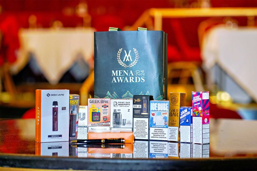 exclusive green MENA Vape Awards 2024 gift bags with e-liquid, disposable vapes and pod vape kits displayed in front  