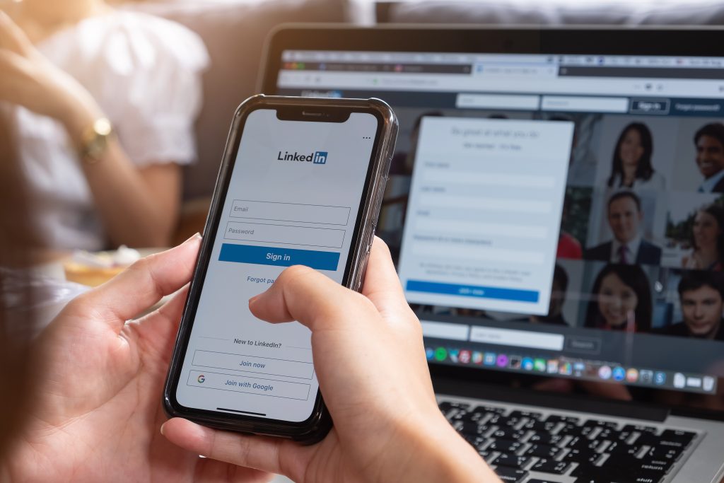 women signing into linkedin using an iphone